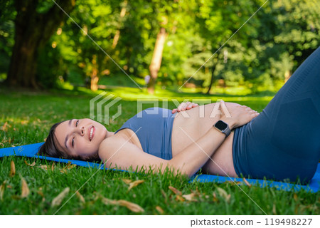 Female resting after practicing fitness exercises in park during sunny spring day 119498227