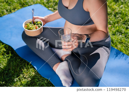 Unrecognizable pregnant woman eating vitamin-rich salad and drinking water Unrecognizable pregnant woman eating vitamin-rich salad and drinking water 119498270