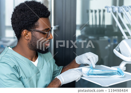 Doctor using tools on dental tray choosing essential dentist equipment 119498484