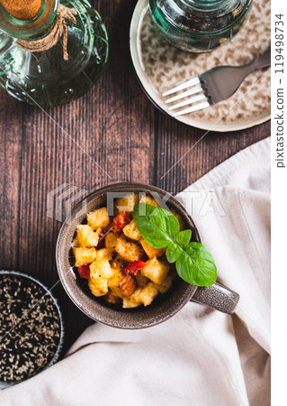 White bread pudding with egg, cheese and pepper in a cup on the table top and vertical view White bread pudding with egg, cheese and pepper in a cup on the table top and vertical view 119498734