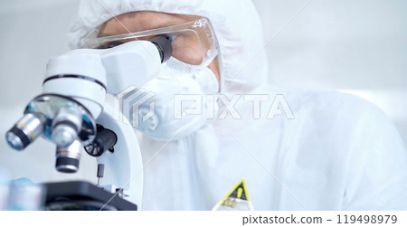 Professional scientist in protective gear is using microscope in a laboratory setting, close-up of researcher. Science and medicine concepts Professional scientist in protective gear is using microscope in a laboratory setting, close-up of researcher. Science and medicine concepts 119498979