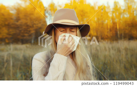 Sick exhausted woman sneezing blow nose using tissue, unhealthy suffering girl feels unwell outdoors 119499043