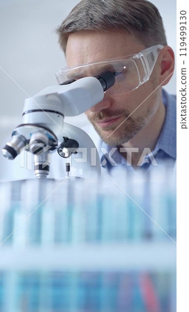 Man scientist with protective glasses and gloves is using micros 119499130