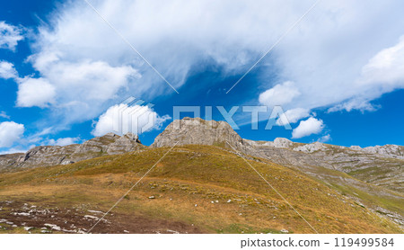 Treeless rocky mountain range against blue sky 119499584