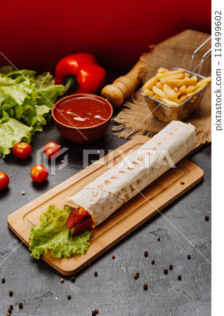 Grilled sausage wrap with fresh lettuce, a perfect quick snack or meal for on-the-go moments Grilled sausage wrap with fresh lettuce, a perfect quick snack or meal for on-the-go moments 119499602