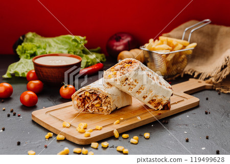 Juicy BBQ chicken wrap with corn filling, cut and styled on board. Ideal for fast-food lovers Juicy BBQ chicken wrap with corn filling, cut and styled on board. Ideal for fast-food lovers 119499628