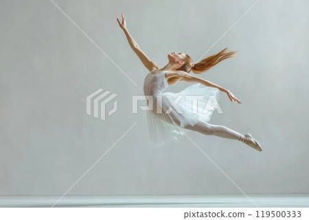 Ballerina is gracefully jumping mid air in a dance studio 119500333
