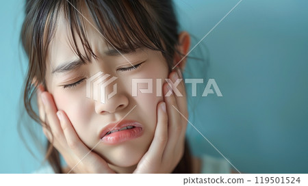 A girl grimacing with both hands on her cheeks 119501524