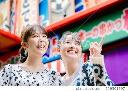 A woman sightseeing in Dotonbori with her friends A woman sightseeing in Dotonbori with her friends 119501697