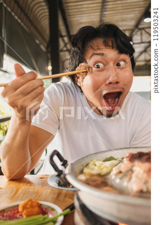 Happy and excited face man eating Moo Kra Ta or Thai BBQ buffet. Happy and excited face man eating Moo Kra Ta or Thai BBQ buffet. 119503241