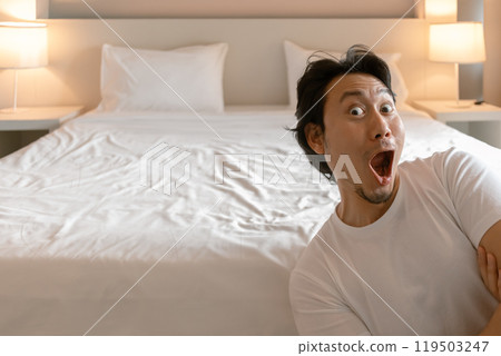 Funny wow face man feeling amazing and present the bedroom of hotel. Funny wow face man feeling amazing and present the bedroom of hotel. 119503247