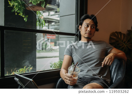 Happy man relaxed in the cafe, drinking iced coffee. Happy man relaxed in the cafe, drinking iced coffee. 119503262