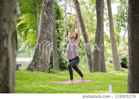 Woman Practicing Yoga in the Park, Relaxing and Meditating Outdoors in a Serene Natural Setting Woman Practicing Yoga in the Park, Relaxing and Meditating Outdoors in a Serene Natural Setting 119503279