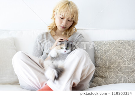 Living with a cat: A woman holding a cat Living with a cat: A woman holding a cat 119503334
