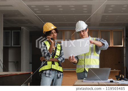 Engineering Team Planning Construction Work with Blueprints and Safety Gear in Modern Building Site Engineering Team Planning Construction Work with Blueprints and Safety Gear in Modern Building Site 119503485