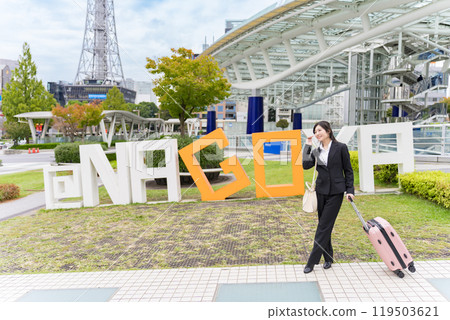 A young businesswoman pulling a suitcase on a business trip to Nagoya 119503621