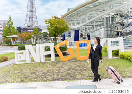 A young businesswoman pulling a suitcase on a business trip to Nagoya A young businesswoman pulling a suitcase on a business trip to Nagoya 119503625