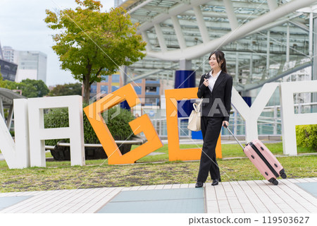 A young businesswoman pulling a suitcase on a business trip to Nagoya A young businesswoman pulling a suitcase on a business trip to Nagoya 119503627