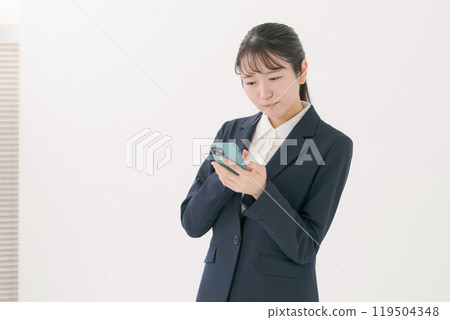 有一套衣服的一名婦女與智能手機 有一套衣服的一名婦女與智能手機 119504348
