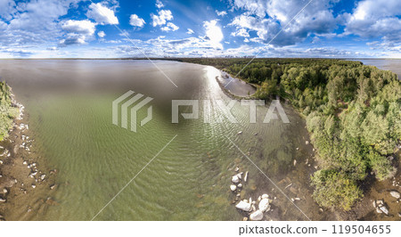 Big lake with green shores in bright sun light and city on horizon, aerial landscape. Recreation concept. Aerial view 119504655