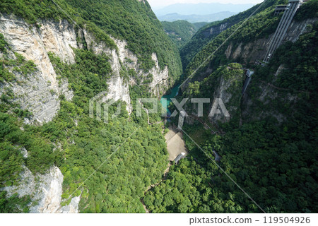 View from the glass bridge down to the forest below. The bridge spans the canyon between two mountain cliffs in Zhangjiajie National Forest Park in the northwest of Hunan province. 119504926