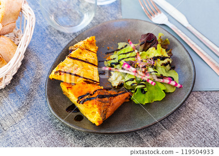 Traditional Spanish potato chorizo tortillas with lettuce closeup Traditional Spanish potato chorizo tortillas with lettuce closeup 119504933