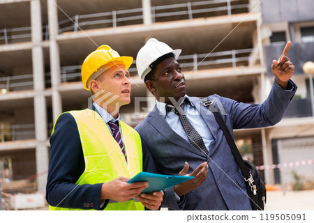 Two architect, civil engineer or building contractor colleagues on construction site 119505091