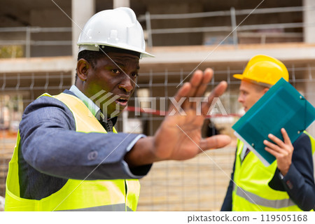 Head of construction site prohibits photographing and closes camera lens with hand 119505168