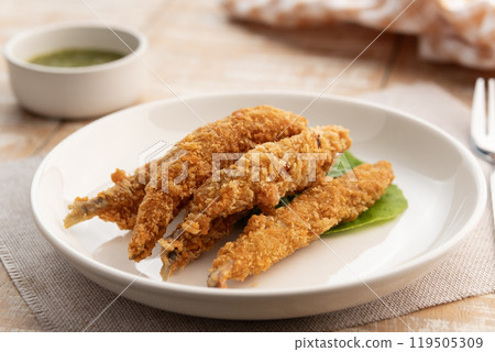Deep fried Capelin Fish (Shishamo),Thai fried battered egg fish in white plate.snack food served with seafood sauce. Deep fried Capelin Fish (Shishamo),Thai fried battered egg fish in white plate.snack food served with seafood sauce. 119505309