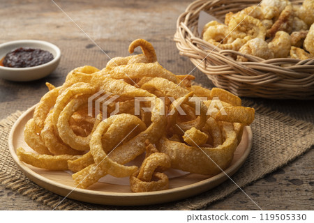 Crispy pork rinds,deep fried pork skin in wooden plate,yummy snacks food. Crispy pork rinds,deep fried pork skin in wooden plate,yummy snacks food. 119505330