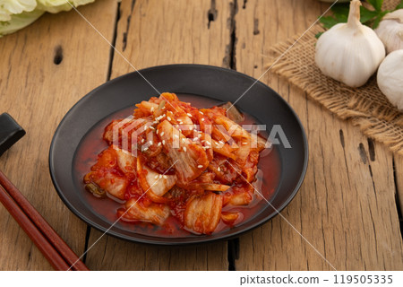 Napa cabbage kimchi topped with white sesame seed in black plate,Korean fermented side dish food. 119505335
