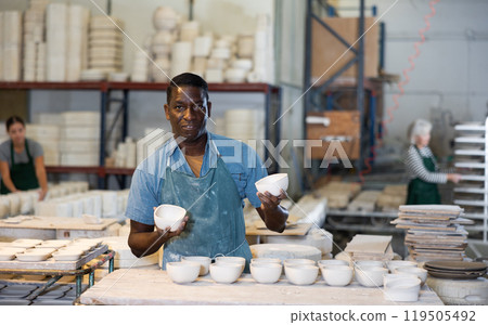 African american artisan having ceramics in hands and standing in workshop 119505492
