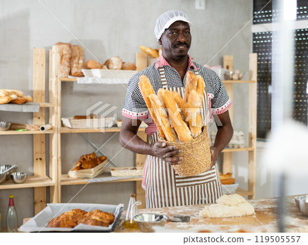 Successful African baker presenting golden baguettes in bakery Successful African baker presenting golden baguettes in bakery 119505557