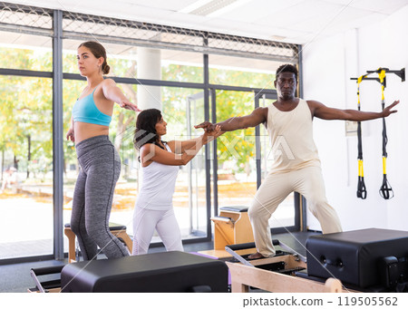 Multiracial people having pilates workout on reformers with trainer Multiracial people having pilates workout on reformers with trainer 119505562