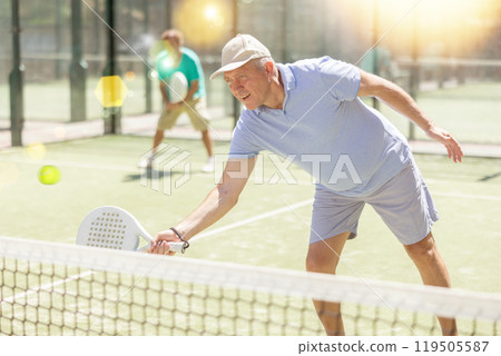 Elderly and adult men playing doubles padel Elderly and adult men playing doubles padel 119505587