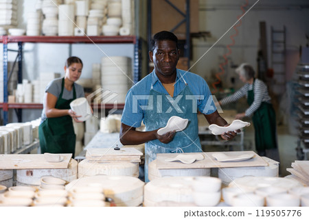 Man potter with new crafted decorative plates Man potter with new crafted decorative plates 119505776