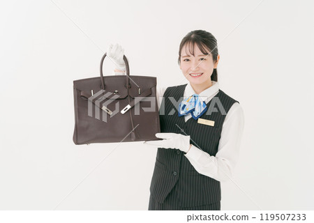 A female staff member appraising a used bag 119507233