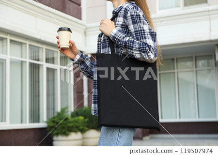 A woman with coffee and a bag on her shoulder 119507974