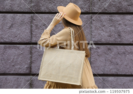 A woman in a hat and a bag on her shoulder 119507975