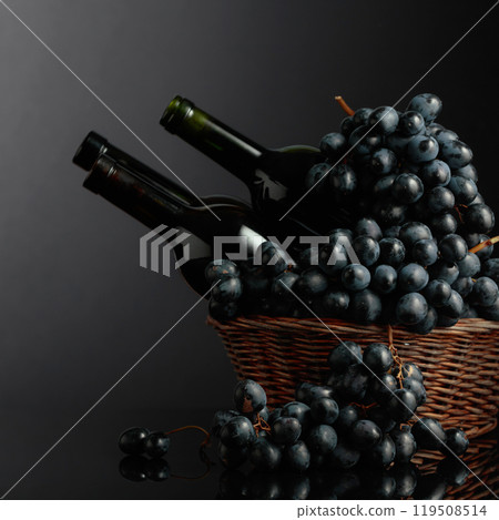 Red wine and blue grapes on a black reflective background. Red wine and blue grapes on a black reflective background. 119508514
