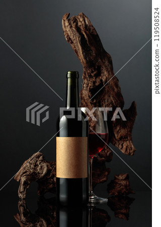 Red wine and old weathered snag on a black background. 119508524