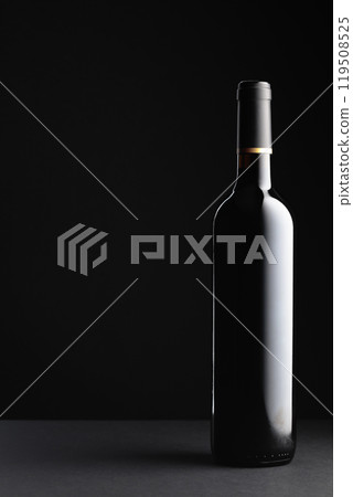 Unopened bottle of red wine on a black background. 119508525