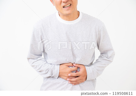 Middle-aged man suffering while holding his lower abdomen Middle-aged man suffering while holding his lower abdomen 119508611