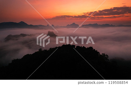 Aerial View of Morning fog and mountains as the sun rises from above 119508854