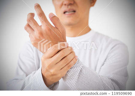 Middle-aged man suffering while holding his wrist 119509690