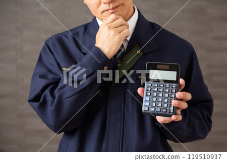 一位穿著工作服、拿著計算器、憂心忡忡的中年商人 119510937
