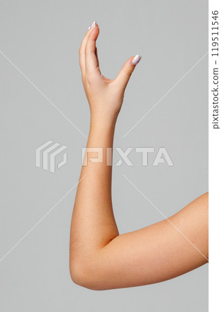 A raised hand signals engagement and communication in a simple, neutral setting 119511546
