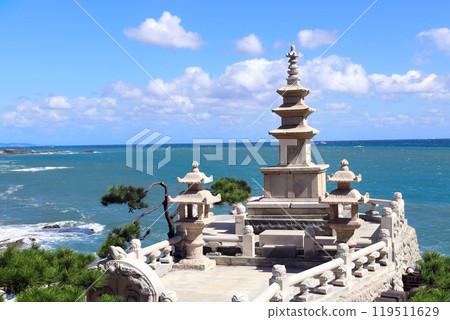 Famous Three-story pagoda on a rocky seashore, Haedong Yonggungsa temple, Busan, South Korea. Sea sceneries of Haedong Yonggung temple with ancient stone pagoda 119511629