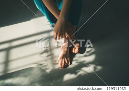 Barefoot woman and window light 119511985