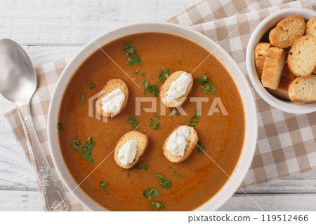 Thick rich fish soup Soupe de Poisson served with croutons and aioli sauce close-up in a bowl. Horizontal top view Thick rich fish soup Soupe de Poisson served with croutons and aioli sauce close-up in a bowl. Horizontal top view 119512466
